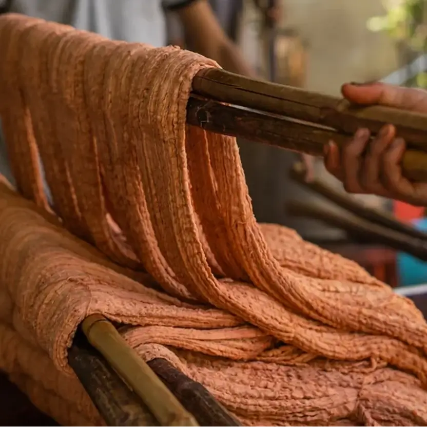 A close-up of thick, textured terracotta-coloured fabric, showing the process